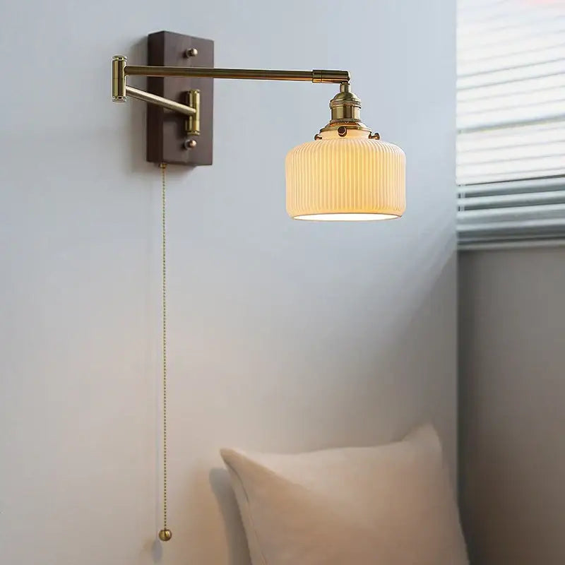 Adjustable brass wall sconce with ribbed glass shade bedroom light