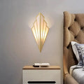 Art deco gold-toned wall light with diamond shape modern geometric fan design and frosted glass panels for bedroom use