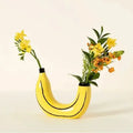 Yellow banana shape resin flower vase with black curved lines and black rim for decorative use