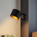 Contemporary black and gold metal drum wall sconce with brass accents for bedroom lighting