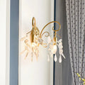 Contemporary brass wall mount light with gold-toned curved arms and dangling clear teardrop crystal wall pendants
