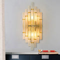 Contemporary gold finish wall sconce with vertical crystal tubes and metallic accents for bedroom lighting