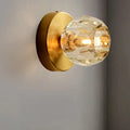 Contemporary golden wall mount lamp with faceted glass shade living room