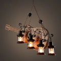 Rustic guitar pendant light with four black lantern-style lights in light wood and black metal finish by decorbites