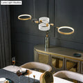 Modern gold and white geometric metal light fixture with circular rings and black accent for dining room gold ring island