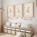 Three framed prints of watercolor-style rabbits in beige and cream tones in light wood with white matting wall art set bohemian style