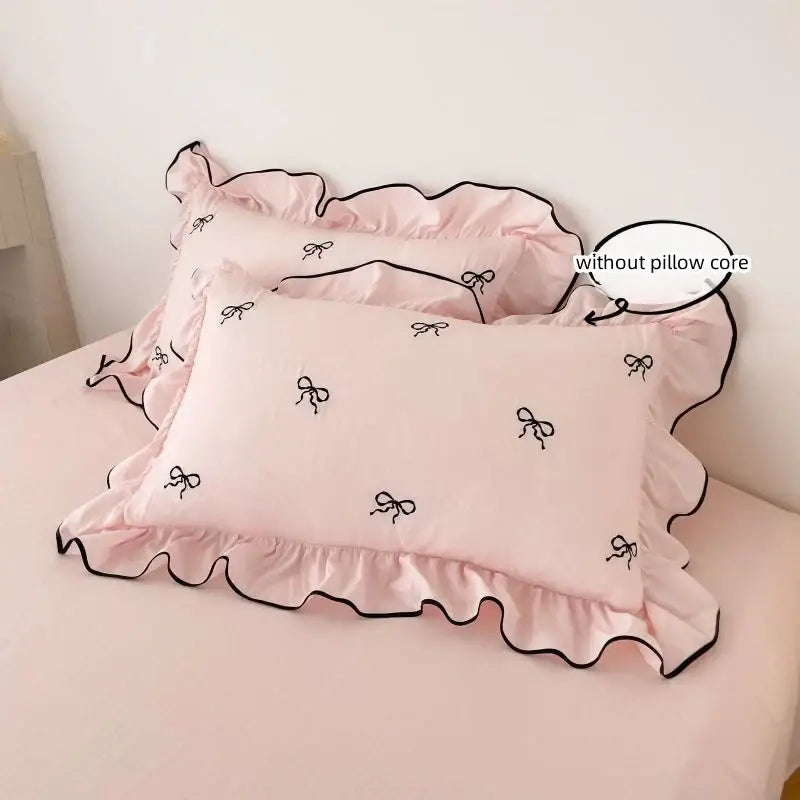 Pink pillowcases with black bow embroidery and ruffled edges from decorbites™ bow embroidery bedding set