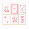 Set of six framed watercolor pink wall art prints featuring cherries, bows, cards, butterflies, and balloon dog for girls room