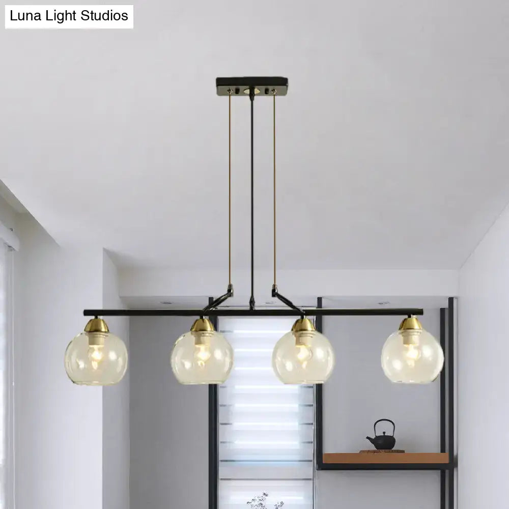 Modern black metal chandelier with four clear prismatic glass globe shades and brass accents for dining hall lighting