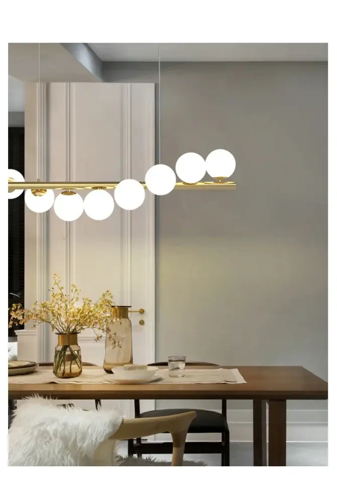 Gold-toned DecorBites™ contemporary LED glass ceiling chandelier with horizontal bar and white spherical bulbs