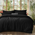 DecorBites™ black satin-like cotton duvet cover set with matching pillows and a textured accent pillow in center