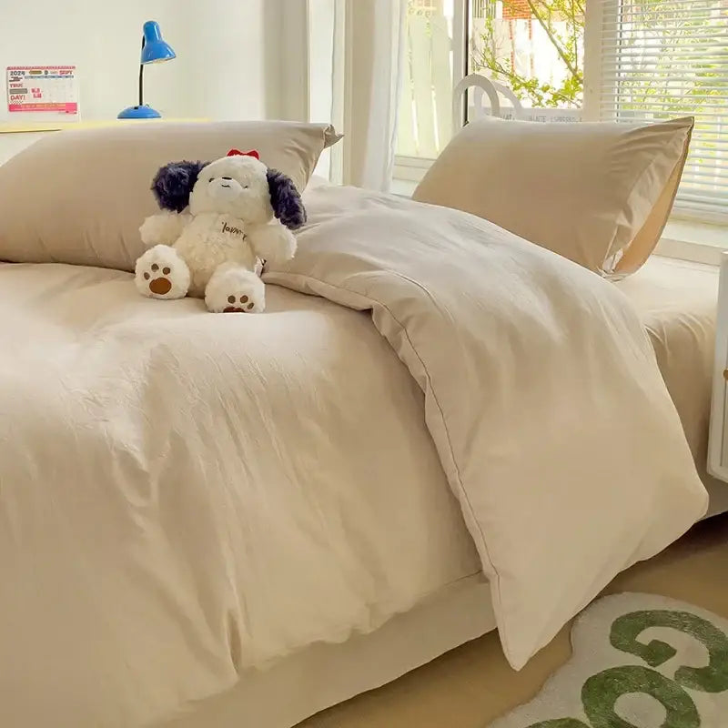 Cream-colored soft-textured cotton bedding set with duvet cover and plush stuffed dog toy on top from decorbites
