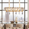 Gold-toned DecorBites™ crystal drop island lighting with modern clear oval design and smoky crystal accents for dining hall