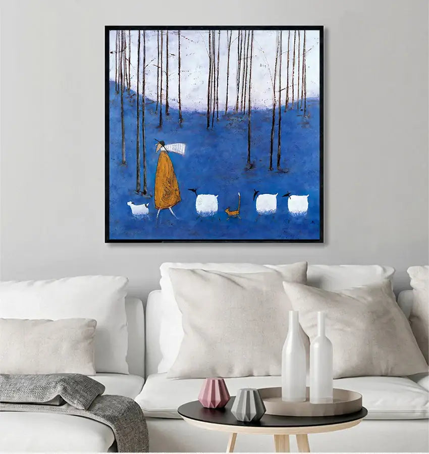 Blue-framed canvas wall art featuring a stylized figure in an orange robe walking with sheep through a forest scene