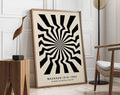 A framed decorbites™ geometric bauhaus canvas poster with bold black and cream radial stripes in a light wood frame