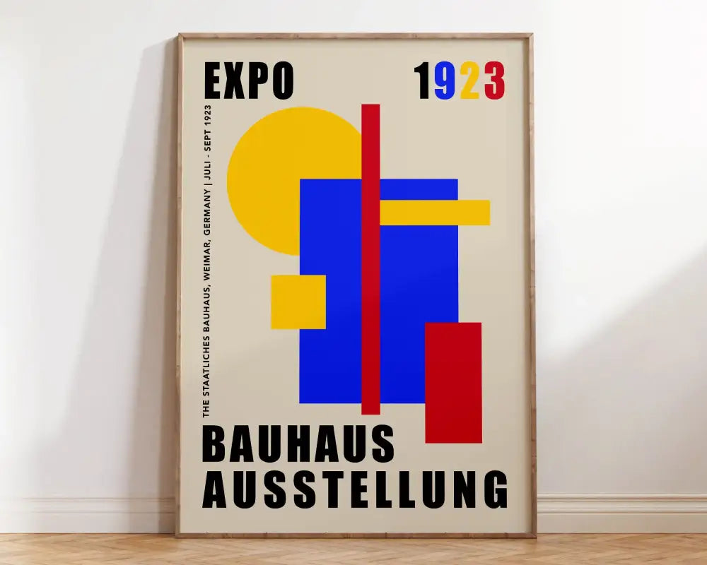 A framed geometric bauhaus canvas print with yellow blue and red shapes and black text for modern home decor