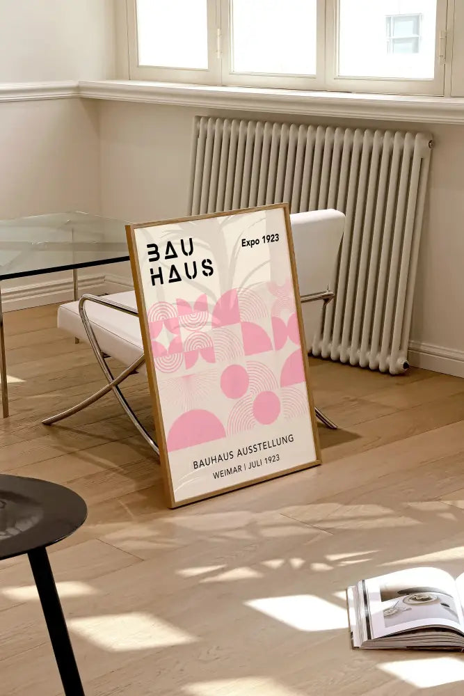 A framed decorbites™ geometric bauhaus canvas print with pink patterns and black text in a light wood frame