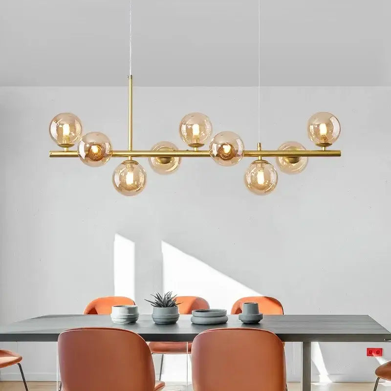 Gold-toned DecorBites™ glass ball ceiling chandelier with amber glass globes arranged on a horizontal bar for home lighting