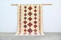 Beige woven decorbites handmade moroccan azilal rug 236x155cm with geometric diamond and arrow patterns in orange red pink and black