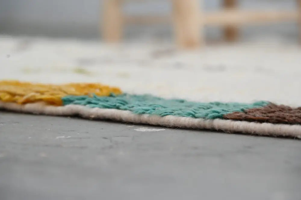 Colorful moroccan handmade azilal rug with woven edge featuring yellow teal and brown yarn bands 237x146 cm