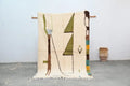 Cream-colored handmade traditional azilal rug with olive green brown and teal geometric patterns moroccan handmade