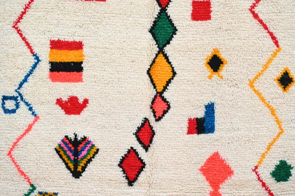 Cream-colored decorbites™ handmade traditional azilal rug 242x140cm with vibrant geometric patterns and textured surface