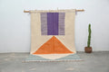 DecorBites™ handmade moroccan azilal rug with beige purple and orange geometric design in natural wool hanging on wooden rod