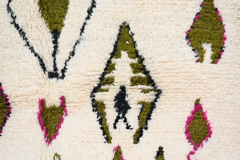 Cream-colored handmade moroccan azilal rug with plush wool texture and bold olive green magenta geometric patterns