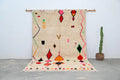Beige handmade moroccan azilal rug with vibrant red orange green pink and black geometric patterns 309x195cm by DecorBites