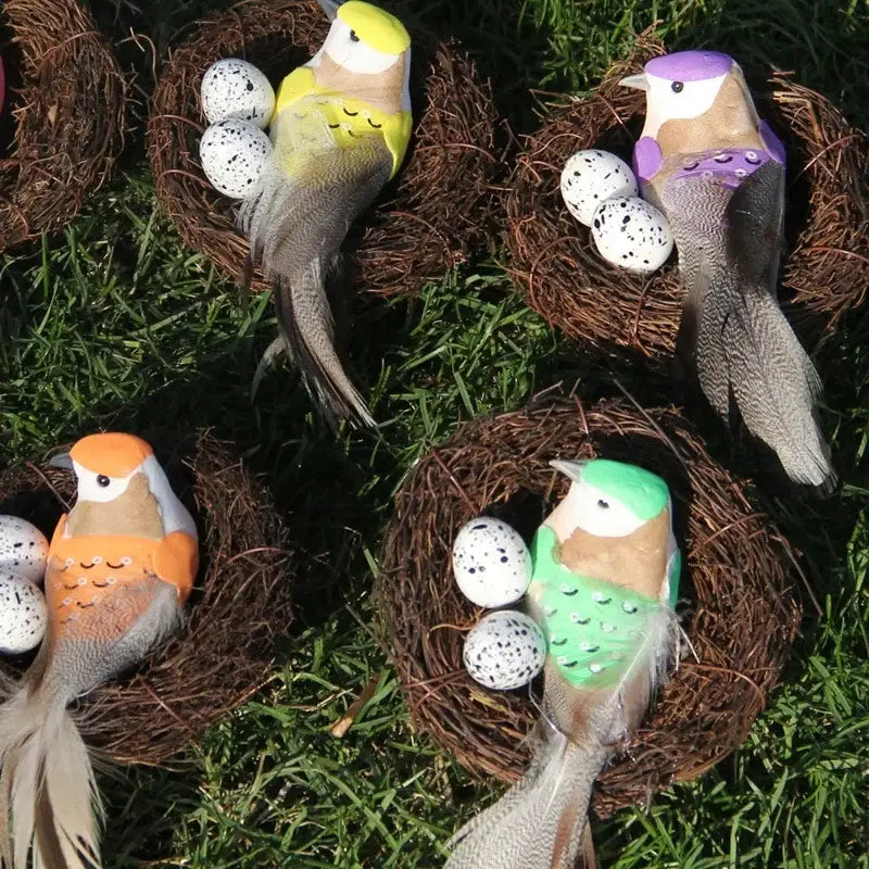 Colorful plastic birds with feathered tails and speckled eggs in handmade round rattan bird nests by DecorBites™
