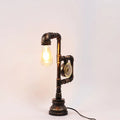 Decorbites industrial metal nightstand lamp with dark aged brass finish and exposed incandescent fluorescent bulb