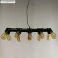 Industrial style ceiling light fixture featuring black metal piping and five amber glass filament bulbs for dining room use
