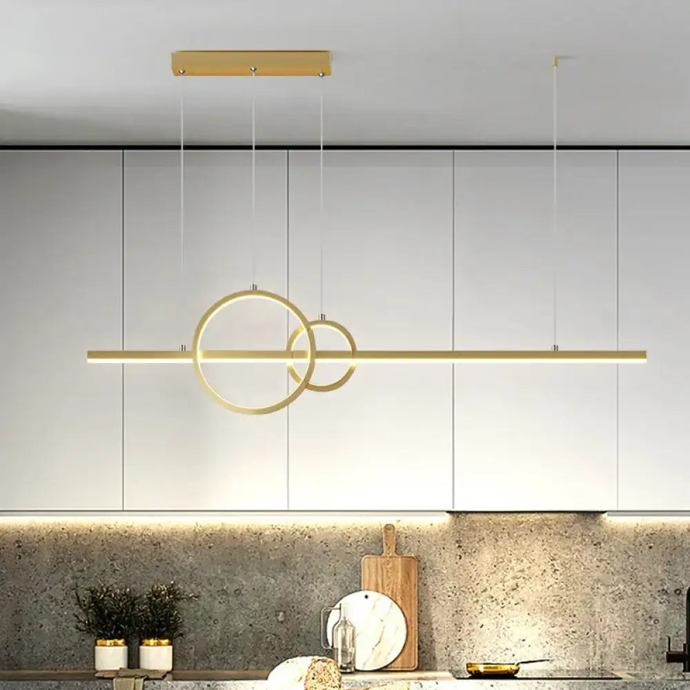 Modern gold-toned decorbites led restaurant island pendant with intersecting rings and warm white lighting above counter