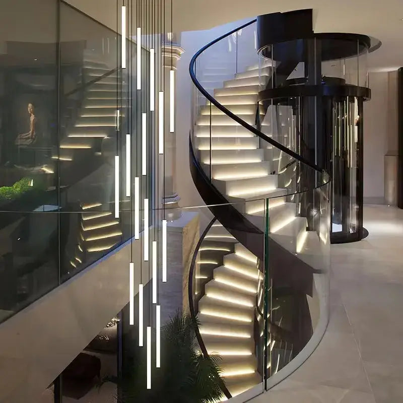 Modern spiral staircase with sleek black metal frame, glass railings, and illuminated white steps for home lighting