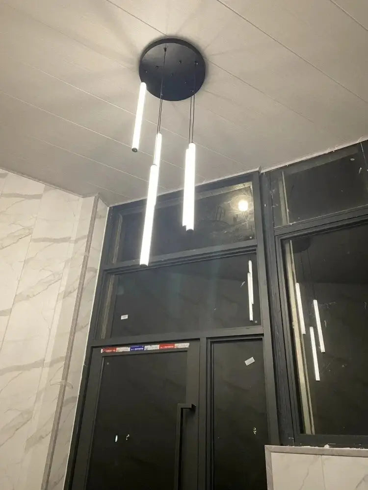 Modern black circular DecorBites™ LED spiral ceiling chandelier with three vertical white LED light tubes