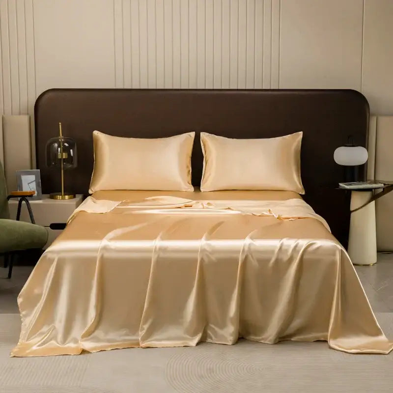 Beige satin bedding set with matching solid color flat sheet and pillowcases featuring a smooth glossy finish