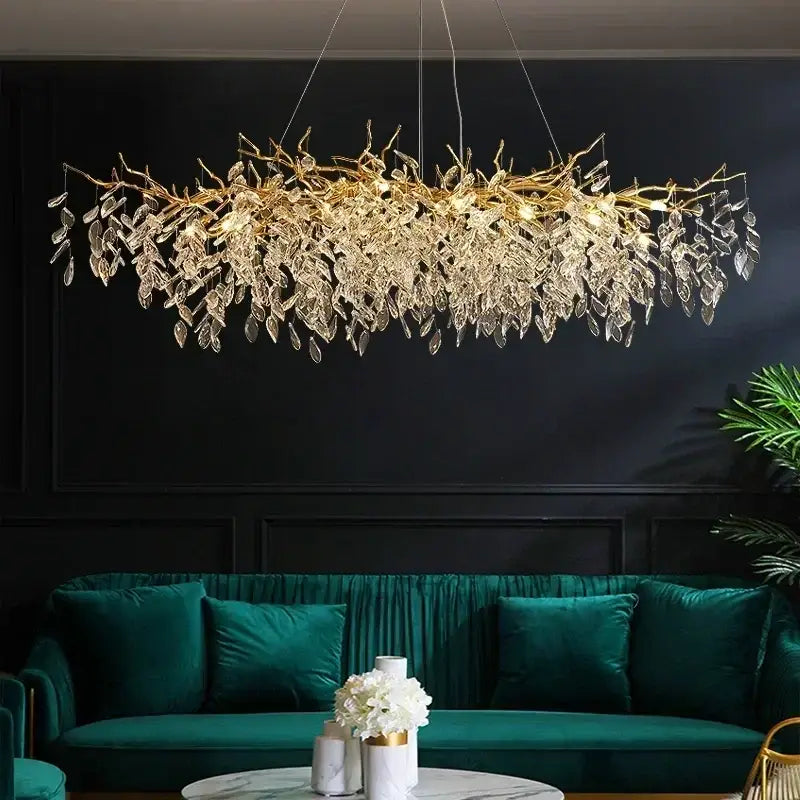 Golden leaf-shaped luxury crystal chandelier with clear crystal droplets and LED lights above green velvet sofa living room