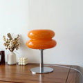 Vibrant orange glossy glass macaron lamp with stacked rounded design and chrome base by italian designer table lamp