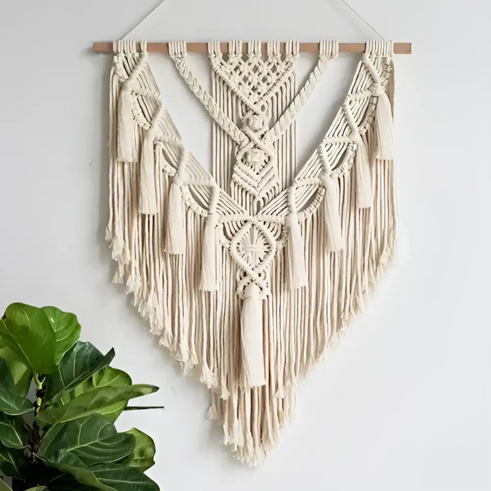 Cream-colored DecorBites macrame wall hanging with intricate knotwork and tassels for chic bohemian home decor