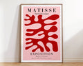 A decorbites™ matisse floral art poster with bold red botanical cut outs on pink in a minimalist wooden frame