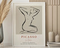 Minimalist framed art print featuring a black line drawing of a nude figure with matisse floral style on beige background