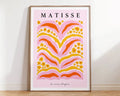A framed decorbites™ matisse floral print featuring bold pink orange and yellow floral patterns on soft pink background