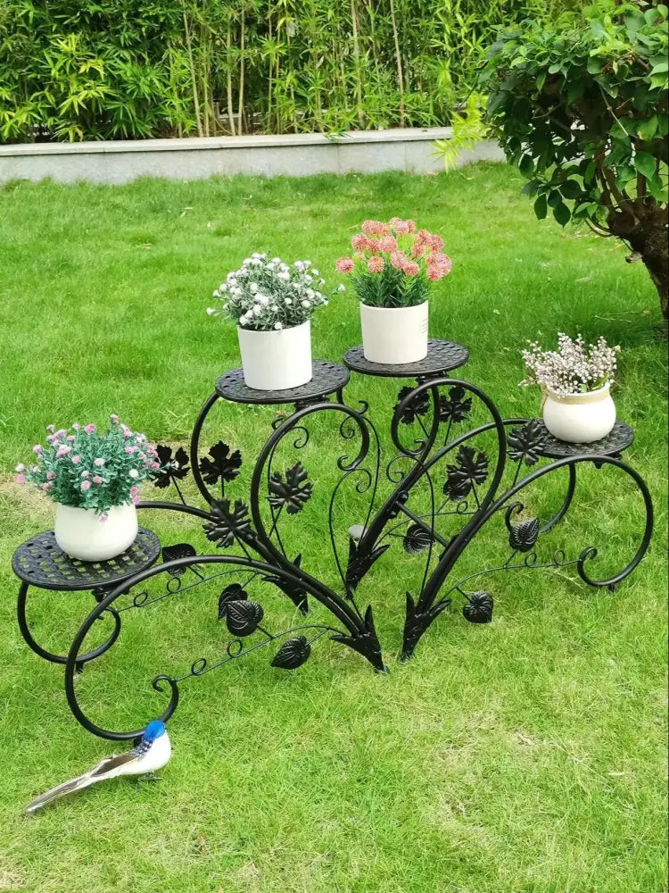 DecorBites metal plant stand in black wrought iron with ornate leaf design and four tiers for white ceramic pots