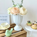 DecorBites™ mini flower arrangement vase with white ceramic fluted pedestal base holding peach cream roses and greenery
