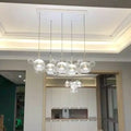 DecorBites minimal brass bubble pendant light with five clear glass heads and modern design suspended by thin cords