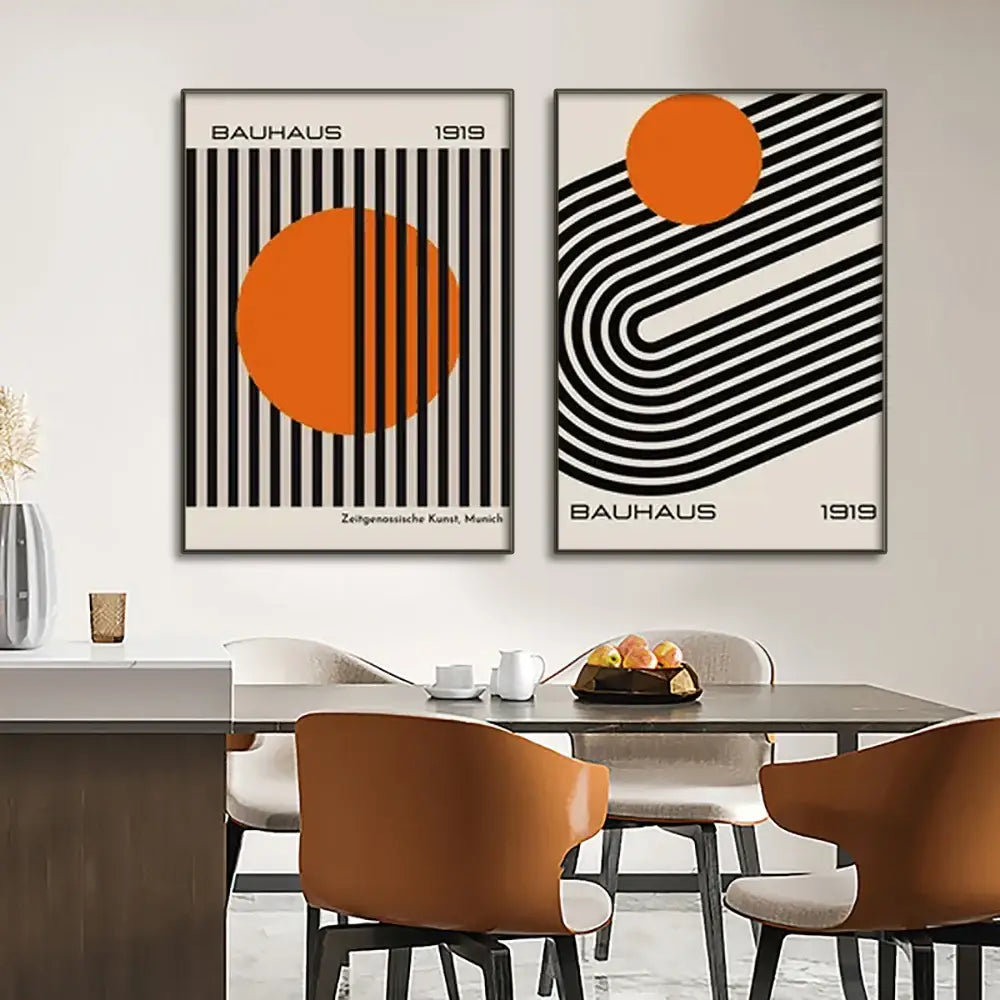 Two framed bauhaus 1919 wall art modern geometric canvas prints with black white patterns and vibrant orange accents
