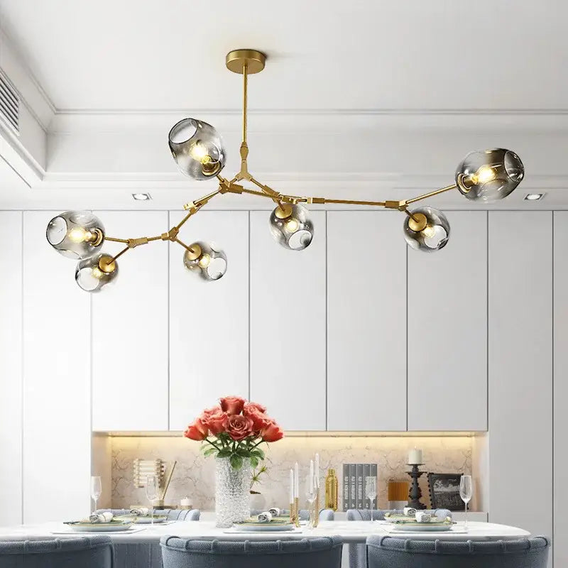 Gold-toned modern DecorBites™ glass ball pendant chandelier with clear glass globe shades in black gold finish