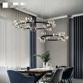 Modern black metal chandelier with adjustable cord featuring clear glass bubble bulbs in concentric circular patterns