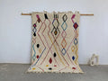 Cream-colored moroccan handmade traditional azilal rug with vibrant pink black blue yellow and red geometric patterns 252 x 160 cm