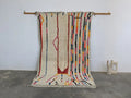 Beige moroccan handmade azilal rug with colorful vertical stripes and central abstract design in pure natural wool